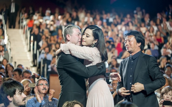 Chinese actress Fan Bingbing (C R) hugs Chinese film director Xiaogang Feng (C L) before receiving the "Concha de Plata" (Silver Shell) award to the best actress during the 64th San Sebastian International Film Festival closing ceremony on September 24, 2016 in the northern Spanish Basque city of San Sebastian.  / AFP PHOTO / Eli Gorostegi